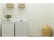 Modern laundry room featuring side-by-side washer and dryer with storage options above at 9497 Minnow Ray Dr, Land O Lakes, FL 34638