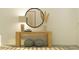Console table with round mirror and decorative elements add elegance to the home's entry area at 9497 Minnow Ray Dr, Land O Lakes, FL 34638