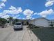 Single-story home with palm trees, spacious driveway, and low maintenance landscaping, featuring a clean and modern aesthetic at 1008 Sago Palm Way, Apollo Beach, FL 33572