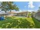 Spacious backyard with lush green grass, a screened-in patio, and a play set, great for outdoor activities at 10409 Glen Willow Ln, Tampa, FL 33647
