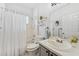 Bright bathroom with a shower-tub combo, white tile, vanity, and a large mirror at 10409 Glen Willow Ln, Tampa, FL 33647