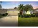 Charming single-story home features a well-manicured lawn, palm trees, and a two-car garage at 10409 Glen Willow Ln, Tampa, FL 33647