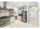 Open kitchen with stainless steel appliances, white cabinetry and unique arched doorways at 10409 Glen Willow Ln, Tampa, FL 33647