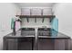 Laundry room featuring front load washer and dryer and built in shelving at 10409 Glen Willow Ln, Tampa, FL 33647