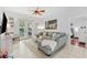 Spacious living room with tile floors, a gray sectional couch, and natural light at 10409 Glen Willow Ln, Tampa, FL 33647