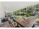 Relaxing screened-in patio with comfortable seating, brick floors, and a rustic wooden table for outdoor enjoyment at 10409 Glen Willow Ln, Tampa, FL 33647