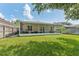 View of the screened-in patio extending from the house, with outdoor seating and access to the lush backyard at 10409 Glen Willow Ln, Tampa, FL 33647