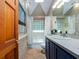 Stylish bathroom with brick accent wall, glass block shower, and modern vanity, offering a unique and updated space at 1136 Granada St, Clearwater, FL 33755