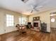 Cozy living room featuring a brick fireplace, hardwood floors, and natural light, creating a warm and inviting atmosphere at 1136 Granada St, Clearwater, FL 33755