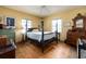 Bedroom with yellow walls and wood floors, featuring traditional decor and ample natural light at 1136 Granada St, Clearwater, FL 33755