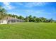Expansive backyard featuring a screened enclosure and lush greenery at 11908 Pilot Country Dr, Spring Hill, FL 34610