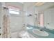 Bathroom with tiled walls, window, a sink and vanity, toilet and bath tub with shower at 11908 Pilot Country Dr, Spring Hill, FL 34610