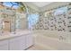 Bathroom featuring a sunken tub, vanity with a sink, and an arched window letting in natural light at 11908 Pilot Country Dr, Spring Hill, FL 34610