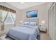 Bedroom featuring blue decor, a picture above the bed, a window and an off white closet at 11908 Pilot Country Dr, Spring Hill, FL 34610