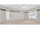 Spacious bedroom with neutral carpeting, a ceiling fan, and a large window at 11908 Pilot Country Dr, Spring Hill, FL 34610