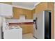 Cozy kitchen with wooden cabinets, white stove, and stainless steel refrigerator at 11908 Pilot Country Dr, Spring Hill, FL 34610
