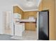Functional kitchen with wooden cabinets, white appliances, and a view of the bathroom at 11908 Pilot Country Dr, Spring Hill, FL 34610
