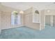 Bright living room with arched windows, pendant lighting, and blue carpet at 11908 Pilot Country Dr, Spring Hill, FL 34610