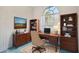 Inviting home office with wood desk, built-in bookshelves, and a large window for natural light at 11908 Pilot Country Dr, Spring Hill, FL 34610