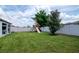 Spacious backyard featuring lush green grass, a play set, and privacy fence at 12138 Criollo Rd, Spring Hill, FL 34610