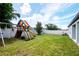 Large backyard features a play set and a white privacy fence at 12138 Criollo Rd, Spring Hill, FL 34610