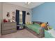 Cozy ' bedroom with blue accent wall, neutral decor, a window for natural light, and carpeted floors at 12138 Criollo Rd, Spring Hill, FL 34610