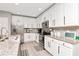 Modern kitchen featuring white cabinets, stainless steel appliances, granite countertops, and a stylish backsplash at 12138 Criollo Rd, Spring Hill, FL 34610