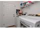 Functional laundry room with a modern washer and dryer, a door, and built-in shelving for ample storage at 12138 Criollo Rd, Spring Hill, FL 34610