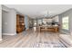 Spacious open-concept living area with wood-look floors, a large dining table, and a kitchen with modern appliances at 12138 Criollo Rd, Spring Hill, FL 34610