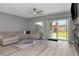 Comfortable living room with a sectional sofa, modern ceiling fan, and sliding glass doors to the backyard at 12138 Criollo Rd, Spring Hill, FL 34610