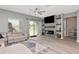 Bright living room features a modern fireplace with stone accent wall, recessed lighting, and a sliding glass door at 12138 Criollo Rd, Spring Hill, FL 34610