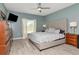 Inviting primary bedroom with a tufted headboard, light blue walls, recessed lights, and wood-look floors at 12138 Criollo Rd, Spring Hill, FL 34610