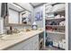 Neat bathroom with an organized vanity area and an open shelving unit stocked with toiletries at 12234 Cider Mill Ln, Hudson, FL 34667