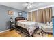 Comfortable bedroom featuring light blue walls, ceiling fan, and hardwood floor at 12234 Cider Mill Ln, Hudson, FL 34667