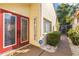 The home features double red doors with a welcome sign and quaint outdoor decor at 12234 Cider Mill Ln, Hudson, FL 34667