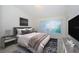 Comfortable bedroom featuring a large window, neutral walls and carpet, stylish gray bedding, and matching lamps at 1241 Redondo Way, Wesley Chapel, FL 33543
