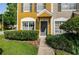 Well-manicured front lawn leading to a townhouse entrance with green front door and storm door at 1241 Redondo Way, Wesley Chapel, FL 33543