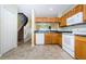 Functional kitchen with white appliances, ample cabinet space, and easy access to the staircase at 1241 Redondo Way, Wesley Chapel, FL 33543