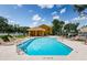 Community pool with lounge chairs, blue water, and clear sky, a poolside cabana at 1241 Redondo Way, Wesley Chapel, FL 33543
