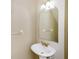 Well-lit powder room with a pedestal sink, decorative mirror, and modern fixtures at 1241 Redondo Way, Wesley Chapel, FL 33543