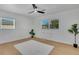 Bedroom with ceiling fan, light wood floors, neutral paint, two windows, a desk and a white area rug at 1320 Dixie S Ln, St Petersburg, FL 33707