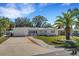 Beautiful single-story home with a manicured front yard and driveway, showcasing its curb appeal and serene setting at 1320 Dixie S Ln, St Petersburg, FL 33707