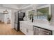 Bright kitchen with farmhouse sink, stainless steel appliances, and wood-look flooring at 1320 Dixie S Ln, St Petersburg, FL 33707