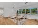 Bright living room featuring two sofas, wood floors, area rug, and a window with a view of the lush outdoors at 1320 Dixie S Ln, St Petersburg, FL 33707