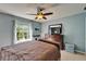 Charming bedroom featuring a dresser, TV, and a cozy bed beneath a ceiling fan, ideal for relaxation at 13252 Graham Yarden Dr, Riverview, FL 33579
