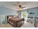 Comfortable bedroom with natural light, complemented by a ceiling fan and neutral decor, offers a tranquil space at 13252 Graham Yarden Dr, Riverview, FL 33579
