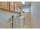 Practical laundry room includes modern washer and dryer, complemented by cabinetry and a window at 13252 Graham Yarden Dr, Riverview, FL 33579