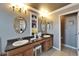 A well-lit bathroom with a vanity area, double sinks, granite countertop and decorative oval mirrors at 13252 Graham Yarden Dr, Riverview, FL 33579