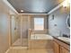 A bathroom featuring a glass shower enclosure, soaking tub, neutral tile, and granite countertop at 13252 Graham Yarden Dr, Riverview, FL 33579