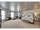 Spacious main bedroom with neutral tones, chaise lounge, bedside tables and lamps, exercise bike, and carpeted floor at 13252 Graham Yarden Dr, Riverview, FL 33579